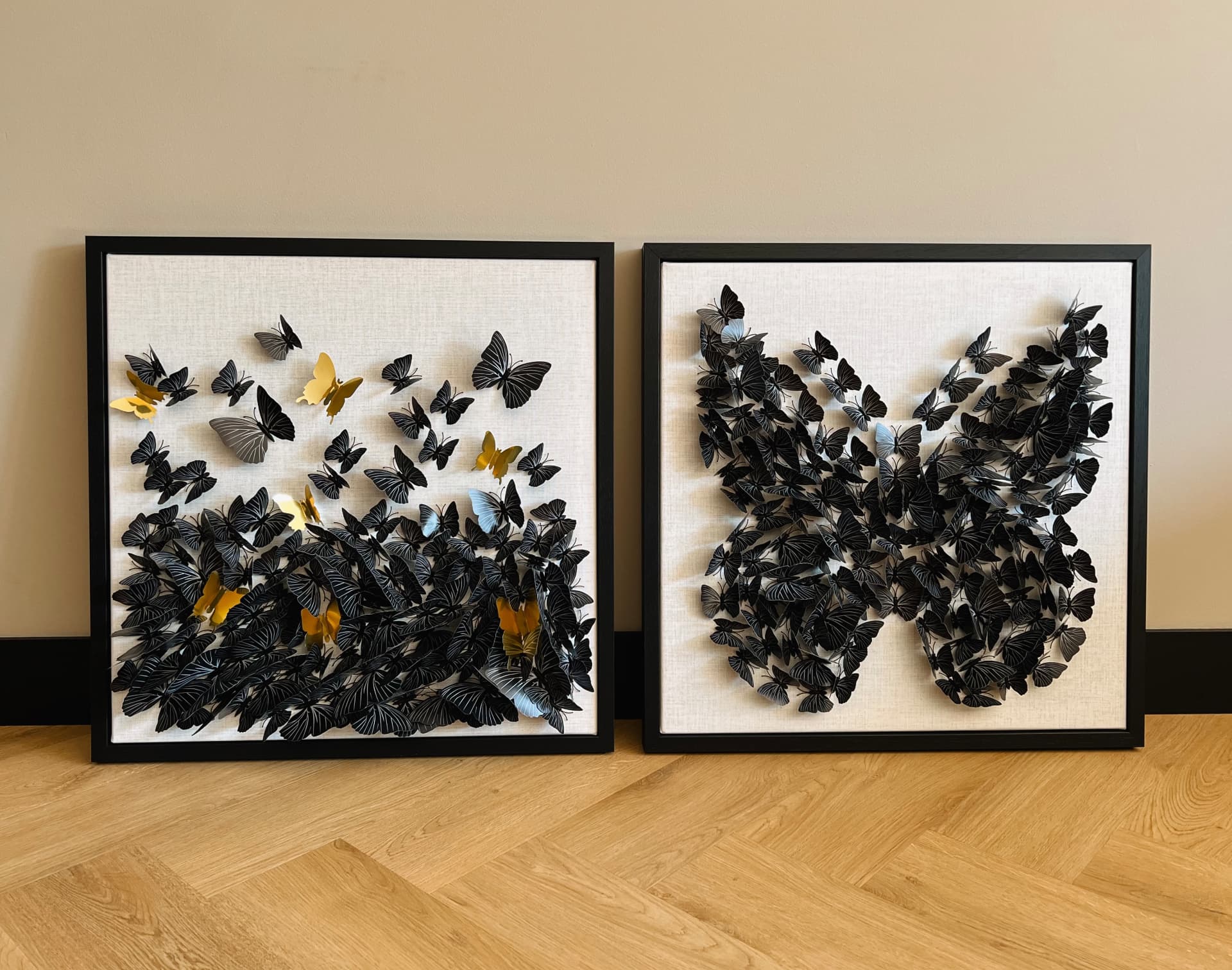 Twee vierkante wanddecoraties met zwarte en gouden vlinders