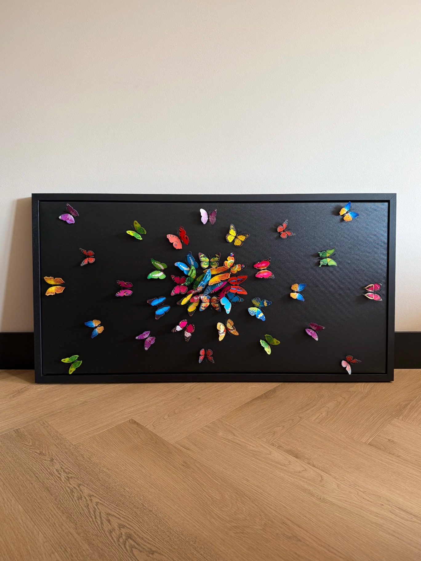 Wanddecoratie met kleurrijke vlinders op zwarte achtergrond
