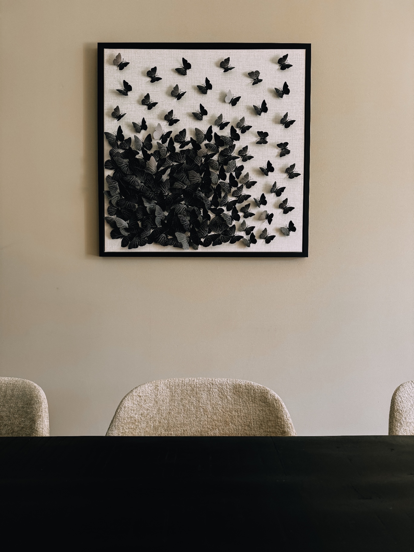 Wanddecoratie met zwarte vlinders boven eettafel